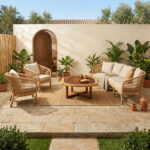 Nunu round coffee table made of suar wood log slice styled with a rattan sofa set in a sunny Mediterranean outdoor patio