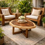 Close up of Nunu round coffee table showing live edge suar wood grain with modern cross base legs on a grey rug