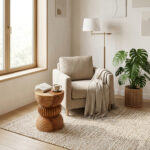 Eclipse Suar Wood Stool used as a decorative side table beside armchair in cozy minimalist living room setting