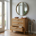 Entryway decor featuring the Lars Woven Sideboard with one drawer open, paired with a large round wall mirror and an umbrella stand
