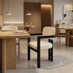 Rivelle Teak Wood Dining Armchair in a luxury restaurant setting, featuring a black wood frame and cream upholstery at a fine dining table