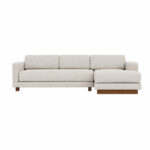 Minimalist cream-colored Aruna L-Shape Sofa with solid wood base, front view against a clean white studio background