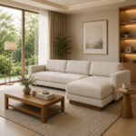 Side angle view of the Aruna L-Shape Sofa in a bright, contemporary living room setup with a minimalist wooden coffee table next to a large floor-to-ceiling window