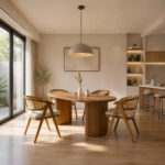 Cozy modern dining room interior displaying the Ellisse Slat Pillar Teak Rattan Dining Set under a minimalist pendant lamp near a large window
