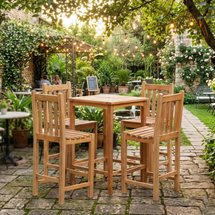 Solid teak outdoor bar table and stools set arranged in a lush courtyard garden cafe with fairy string lights