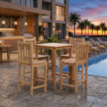 High-quality teak bar furniture set next to a luxury hotel swimming pool and outdoor lounge area during sunset