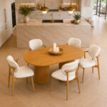 Elara solid teak oval dining table and padded chairs in modern kitchen high angle interior view