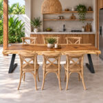 Natural Suar wood dining table with black iron base and dining chairs in a tropical home setting