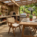 Teak wood dining armchair with woven rattan backrest and beige cushion in an outdoor dining setting