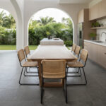 Live edge Suar wood dining table in a minimalist dining room with woven dining chairs
