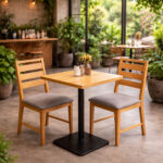Arsy teak wood dining chair with grey foam cushion beside a cafe table