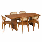 Artisan solid Suar wood dining table paired with teak wood dining chairs featuring woven rattan backrests