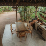 Natural grain and live-edge detail of the solid Suar wood Artisan dining table with teak dining chairs