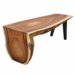 Arvana Suar wood waterfall dining table featuring a sculptural wooden end, natural edge slab top, and black metal legs