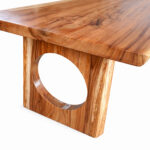Close-up of natural Suar wood grain and circular cut-out detail on the dining table leg