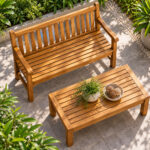 Dhifa teak garden bench beside a wooden coffee table in a landscaped outdoor seating area