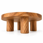 Kavana round suar wood coffee table showing its thick tabletop and four cylindrical legs from a low angle