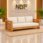 Niwara Solvane teak wood sofa with cream cushions in a furniture showroom