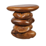 Three-quarter view of a sculptural solid Suar wood accent table with rounded stacked forms