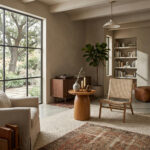 Round solid teak pedestal side table beside lounge chair in reading room