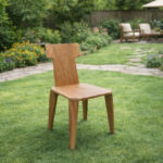 Solid Suar wood dining chair with T-shaped backrest displayed in a garden setting