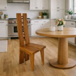 Solid Suar wood H-design dining chair beside a round wooden dining table in a contemporary kitchen