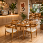 Solid teak dining furniture set with four cushioned Selly chairs in an elegant restaurant