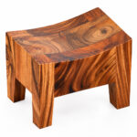 Curved seat and sculpted body of the Suarvo natural Suar wood stool