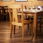 Solid teak dining chair paired with a wooden dining table in a modern dining room