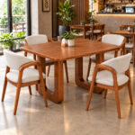 Teakora dining table and four upholstered chairs in a modern cafe interior