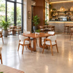 Modern teak dining set with four upholstered chairs in a minimalist cafe interior