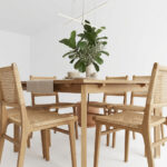 Close-up of woven rattan seat and natural teak wood frame on a dining chair