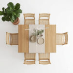 Natural teak dining chairs with woven rattan seats arranged around a wooden dining table Salin ALT