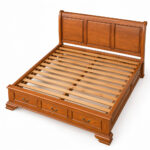 Front three-quarter view of Windsor teak bed frame with paneled headboard and three drawers