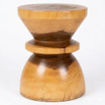 Zuma solid Suar wood accent stool showing its natural grain and rounded hourglass-inspired design